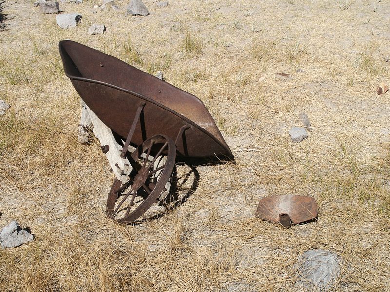 Wheelbarrow with wooden handles and shovel spade.